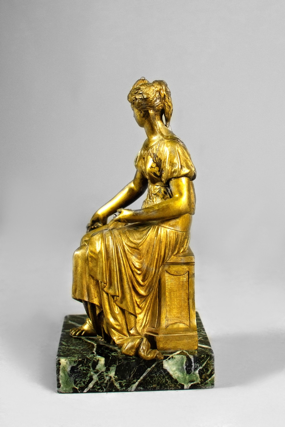 A nineteenth-century gilt bronze sculpture depicting the seated Roman goddess Ceres holding a sheaf of wheat on a square green marble base. View V