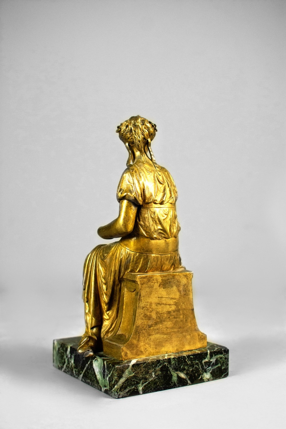 A nineteenth-century gilt bronze sculpture depicting the seated Roman goddess Ceres holding a sheaf of wheat on a square green marble base. View VI