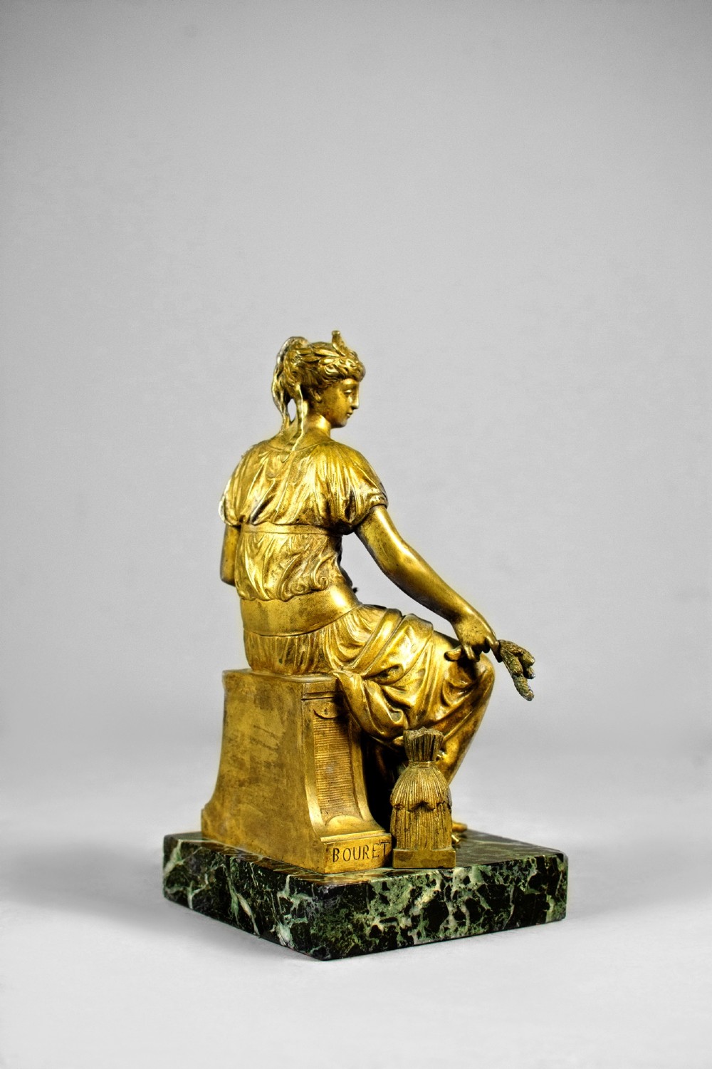 A nineteenth-century gilt bronze sculpture depicting the seated Roman goddess Ceres holding a sheaf of wheat on a square green marble base. View VII