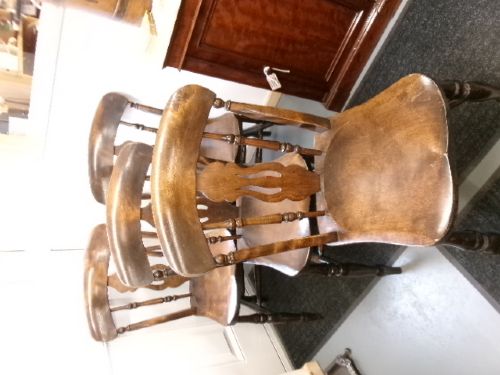 A set of four dark brown wooden fiddle back kitchen chairs featuring turned front legs and solid seats. View II