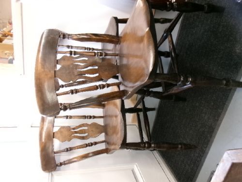 A set of four dark brown wooden fiddle back kitchen chairs featuring turned front legs and solid seats. View IV