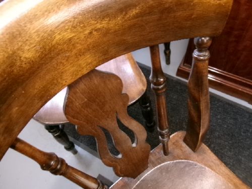 A set of four dark brown wooden fiddle back kitchen chairs featuring turned front legs and solid seats. View VI