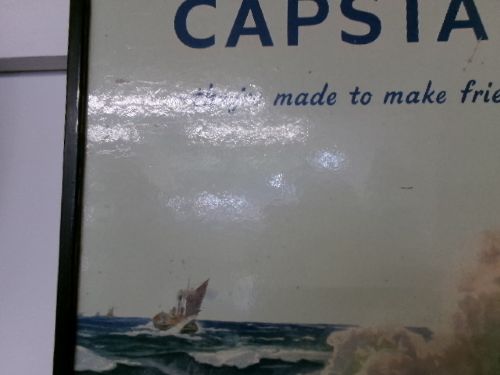 A framed vintage cardboard advertisement for Capstan cigarettes featuring a steam vessel navigating rough seas under text reading Have a Capstan. View IV