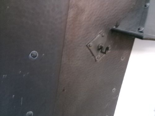 An Arts and Crafts patinated copper firefront featuring a central flared hood canopy and riveted border panels. View IV