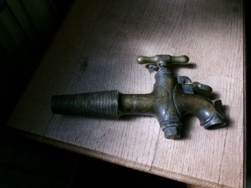 A heavy Victorian brass barrel tap featuring a tapered shaft, curved spout, T-bar handle, and an integrated locking loop mechanism. View II