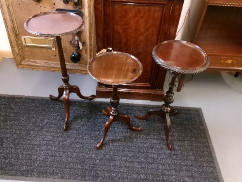 A trio of Edwardian mahogany wine tables featuring turned central pedestals, dished circular tops, and carved tripod cabriole legs. View IX