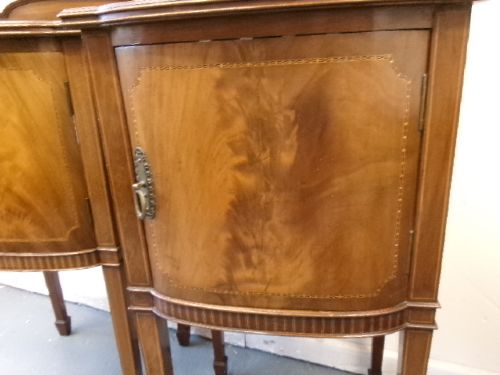 A pair of Edwardian mahogany bedside cabinets featuring bow fronts, satinwood string inlay, shaped upstands, and tapered legs. View II