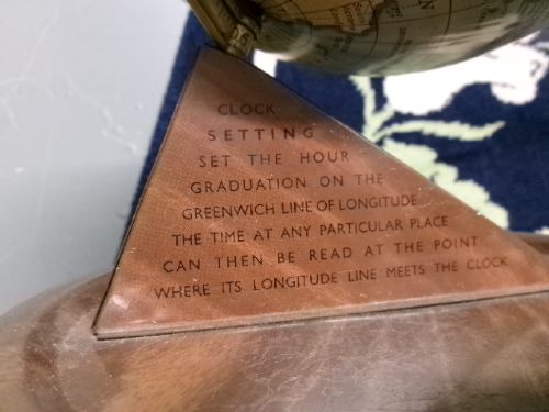 A vintage tinplate world globe with a pale blue lithographed ocean map mounted on a circular metal base with a curved semi-meridian arm. View VI