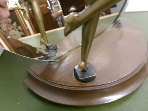 An Art Deco spelter figure of a dancing female posing dynamically in front of a circular bevelled glass mirror set on a wooden plinth base. View II