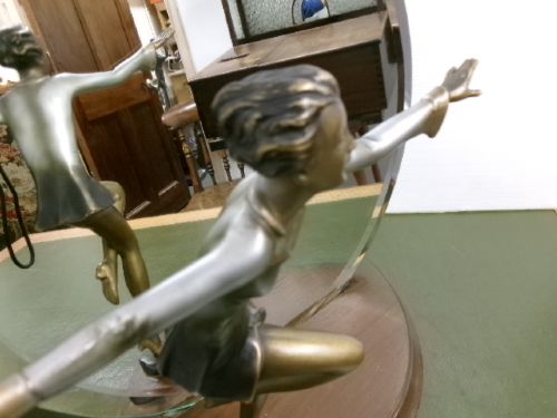 An Art Deco spelter figure of a dancing female posing dynamically in front of a circular bevelled glass mirror set on a wooden plinth base. View III