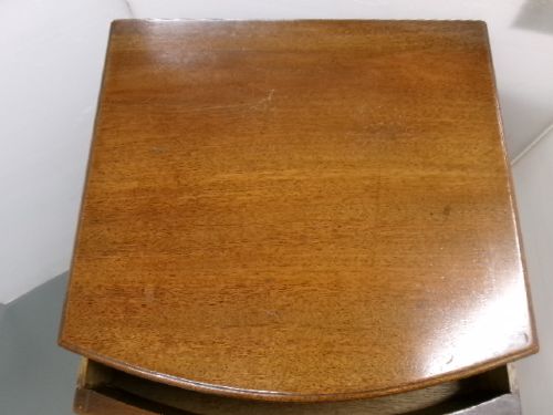 An Edwardian bow-front mahogany cabinet featuring two upper drawers with brass knobs over a panelled cupboard door. View II