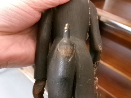 A carved and painted wooden figure of a caricatured man wearing a top hat and tailcoat, holding an umbrella while standing on a rounded grey base. View XIII