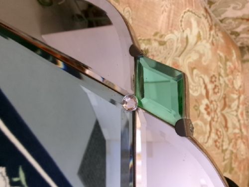 An Art Deco frameless wall mirror featuring peach-tinted geometric border panels, green corner clips, and a scalloped edge silhouette. View VI