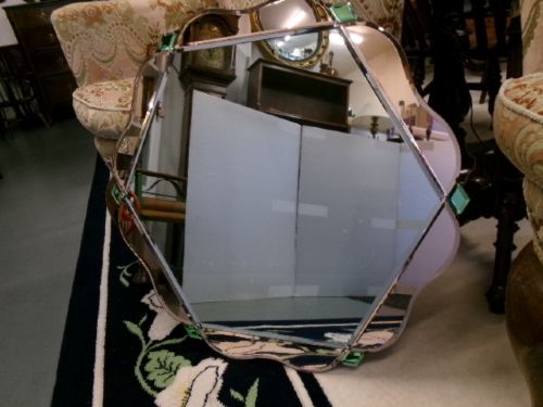 An Art Deco frameless wall mirror featuring peach-tinted geometric border panels, green corner clips, and a scalloped edge silhouette. View VII