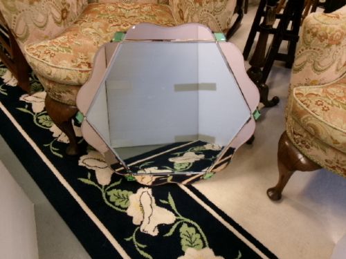 An Art Deco frameless wall mirror featuring peach-tinted geometric border panels, green corner clips, and a scalloped edge silhouette. View IX