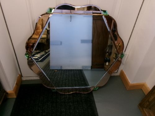 An Art Deco frameless wall mirror featuring peach-tinted geometric border panels, green corner clips, and a scalloped edge silhouette. View XI