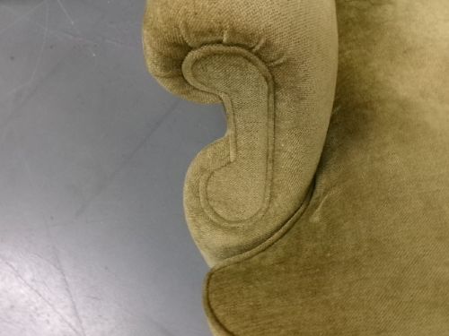A high-backed Georgian style wing armchair upholstered in textured olive green fabric with dark wooden legs. View VIII