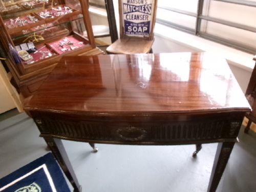 A dark mahogany freestanding cutlery cabinet with a open hinged lid displaying a fitted purple velvet interior with silver-plated flatware. View II