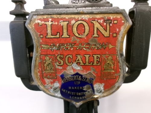 A Victorian cast iron and brass commercial weighing scale featuring a top lion crest, brass pan, and ceramic platform. View VIII