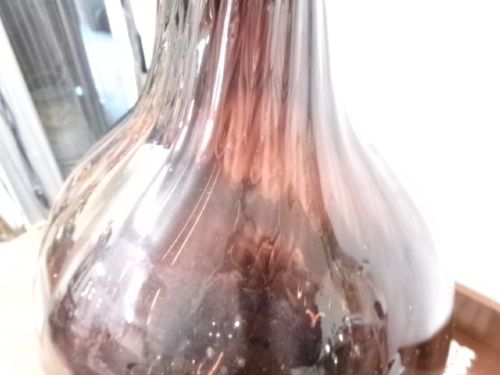 A deep amethyst hand-blown glass bottle featuring a bulbous onion-shaped body, a spiral-ribbed tapering neck, and an applied string lip rim. View VIII
