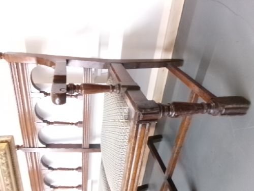 A late Victorian carved walnut three-seater bench featuring an arched spindle backrest, armrests, upholstered seat pads, and turned front legs. View VIII