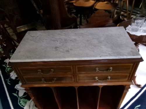 A Victorian mahogany storage unit featuring a white marble top, four inlaid drawers with brass handles, and four open lower vertical compartments. View IV
