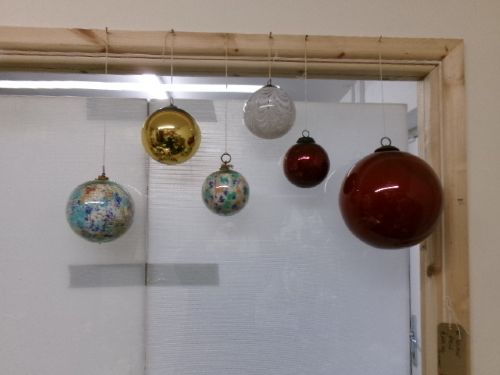 A collection of six assorted antique Victorian hand-blown glass witch balls in gold, red, and speckled colourways suspended by string. View III