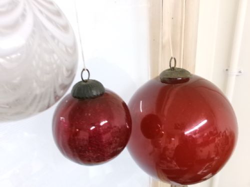 A collection of six assorted antique Victorian hand-blown glass witch balls in gold, red, and speckled colourways suspended by string. View VI