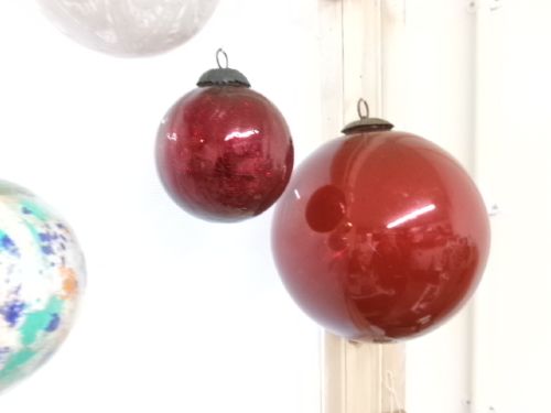 A collection of six assorted antique Victorian hand-blown glass witch balls in gold, red, and speckled colourways suspended by string. View VII
