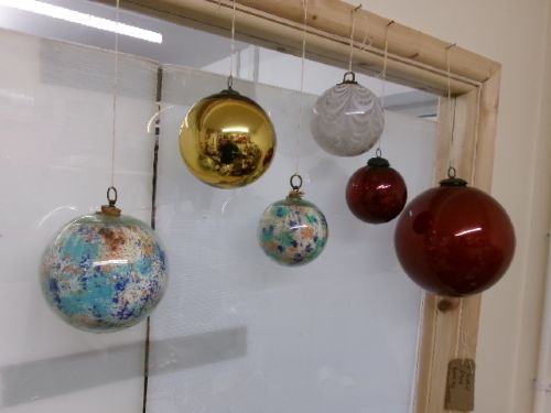 A collection of six assorted antique Victorian hand-blown glass witch balls in gold, red, and speckled colourways suspended by string. View IX