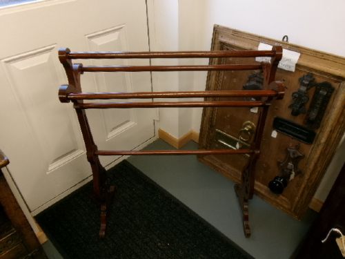 A freestanding Victorian mahogany towel rail featuring carved scrollwork supports and multiple horizontal rails on trestle feet. View V