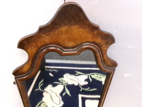An antique walnut wall mirror with an arched, shaped top cresting and moulded frame. View XI