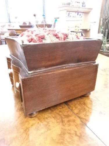 A 19th-century square mahogany pincushion featuring a padded fabric top above a small wooden drawer with two white knobs and bun feet. View IV