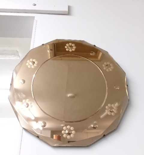 An octagonal Art Deco frameless wall mirror featuring peach-tinted outer glass with etched floral motifs surrounding a central circular mirror plate.