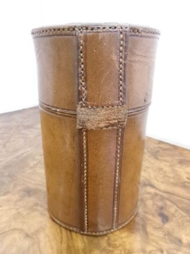 A cylindrical tan leather case opened to reveal four glass flasks fitted with polished silver domed caps. View IX