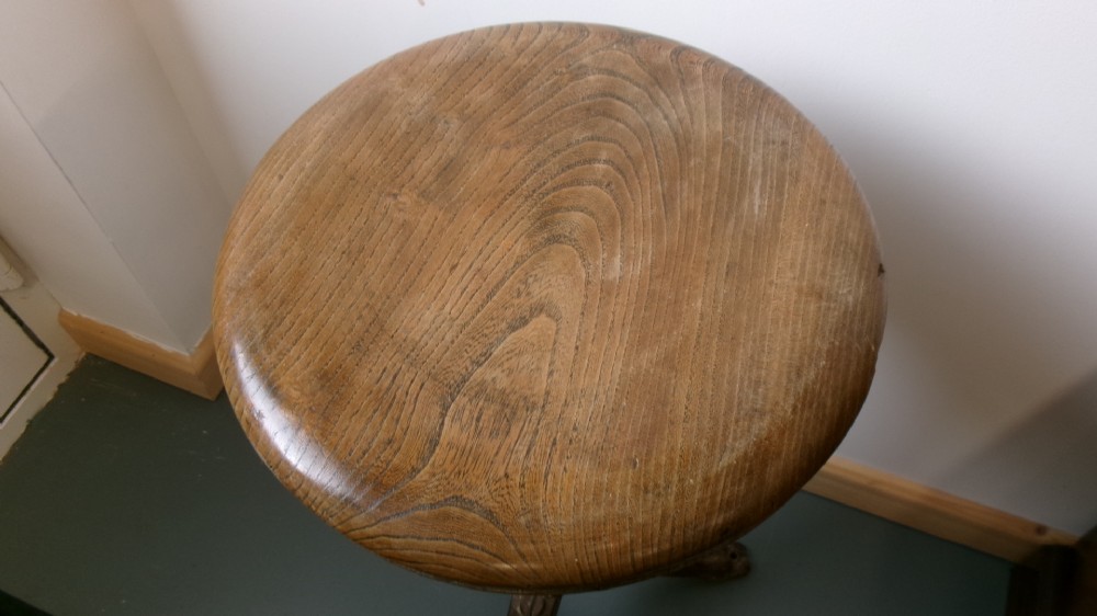 A Victorian revolving stool featuring a circular wooden seat mounted on a cast iron tripod base. View II
