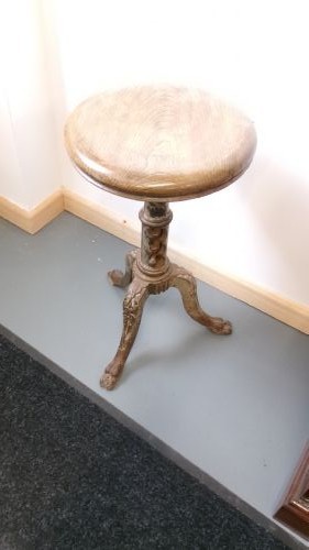 A Victorian revolving stool featuring a circular wooden seat mounted on a cast iron tripod base. View VIII