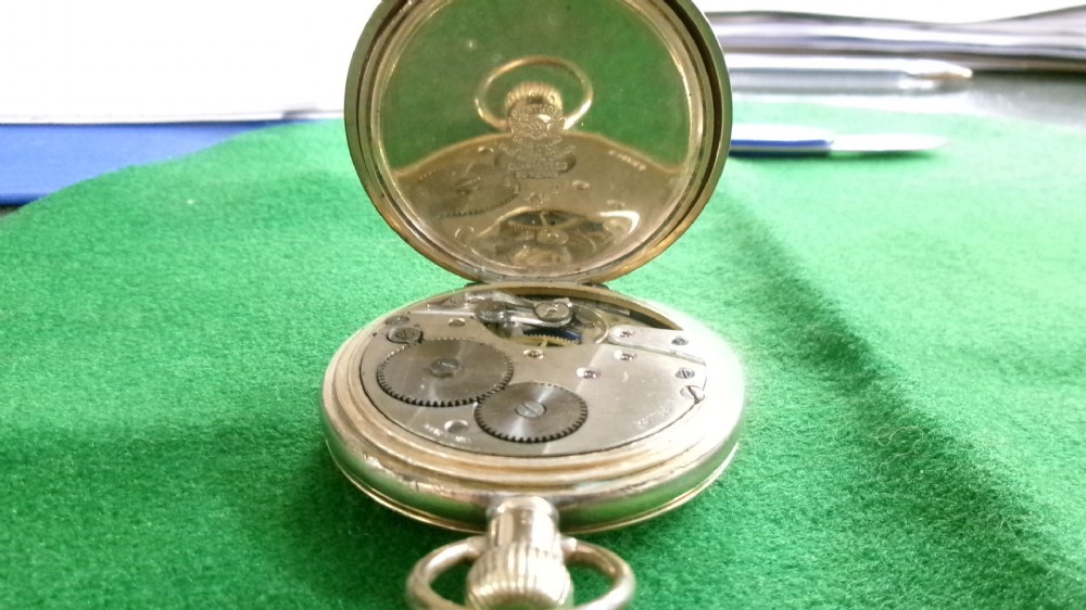 An open gold-plated full hunter pocket watch with a white enamel dial, black Arabic numerals, and a subsidiary seconds dial. View II