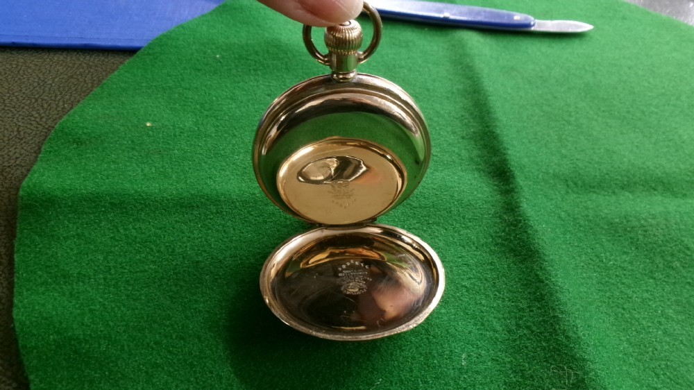 An open gold-plated full hunter pocket watch with a white enamel dial, black Arabic numerals, and a subsidiary seconds dial. View V