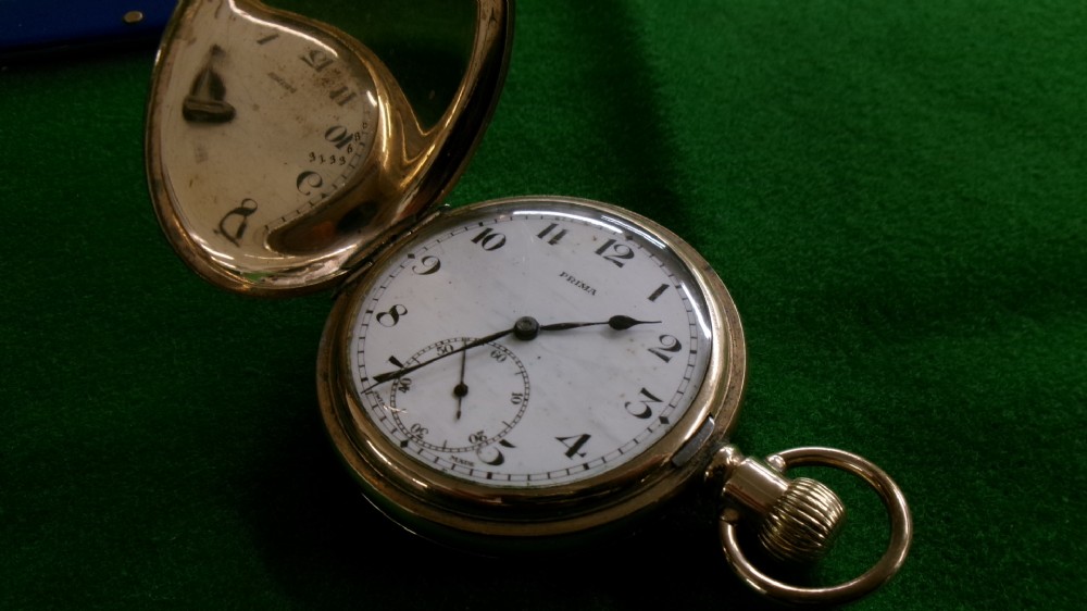 An open gold-plated full hunter pocket watch with a white enamel dial, black Arabic numerals, and a subsidiary seconds dial. View XII