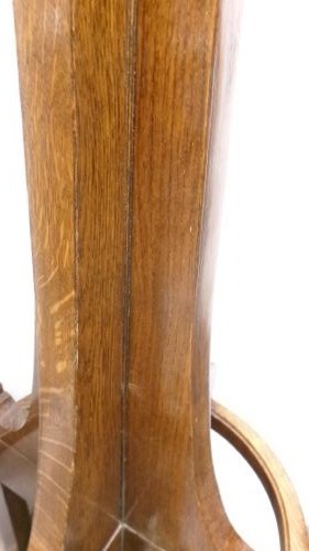 A tall solid oak hat and coat stand featuring multiple brass hooks, a tapered central column, and an integrated circular umbrella holder base. View V