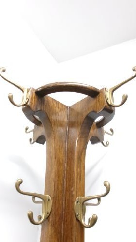 A tall solid oak hat and coat stand featuring multiple brass hooks, a tapered central column, and an integrated circular umbrella holder base. View III