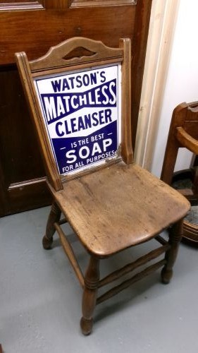 An antique wooden side chair with turned legs featuring an integrated blue and white enamel advertising sign for Watsons Matchless Cleanser Soap set into the backrest. View III