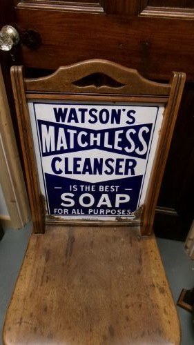 An antique wooden side chair with turned legs featuring an integrated blue and white enamel advertising sign for Watsons Matchless Cleanser Soap set into the backrest. View IV