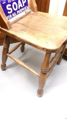 An antique wooden side chair with turned legs featuring an integrated blue and white enamel advertising sign for Watsons Matchless Cleanser Soap set into the backrest. View V