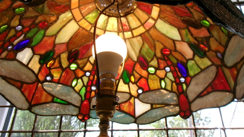 A tall Edwardian brass table lamp featuring an open twist stem and a Tiffany style stained glass dragonfly lampshade. View III