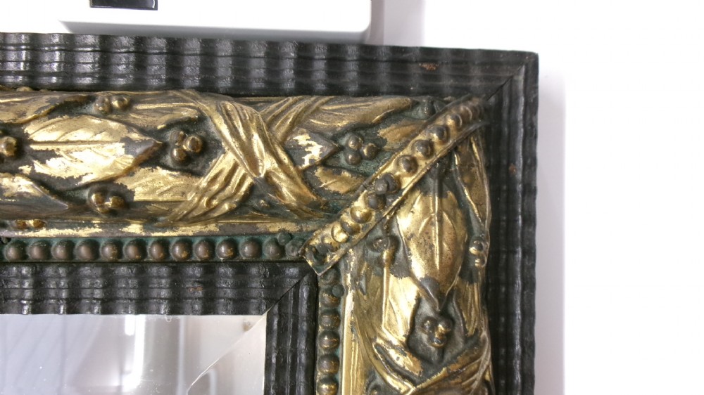 A rectangular Victorian wall mirror featuring a dark wooden frame bordered with ornate gilt brass foliate leaf moulding. View II
