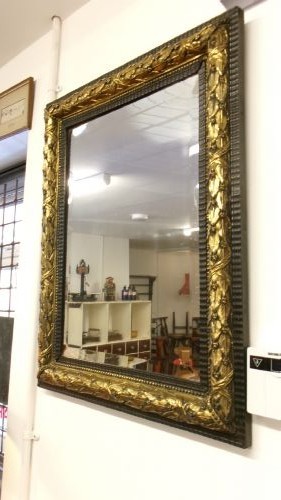 A rectangular Victorian wall mirror featuring a dark wooden frame bordered with ornate gilt brass foliate leaf moulding. View V
