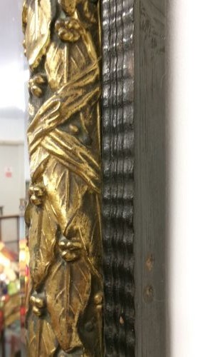 A rectangular Victorian wall mirror featuring a dark wooden frame bordered with ornate gilt brass foliate leaf moulding. View VI