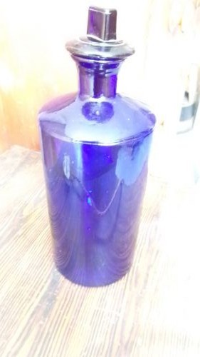 A tall Victorian cobalt blue glass apothecary bottle featuring a dark glass lollipop stopper and a gilt-bordered shield label inscribed SYR VIOLAE. View IV